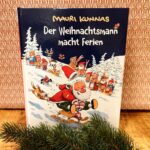 Das Buch Der Weihnachtsmann macht Ferien steht vor einem gemusterten Hintergrund. Davor liegt ein Tannenzweig.
